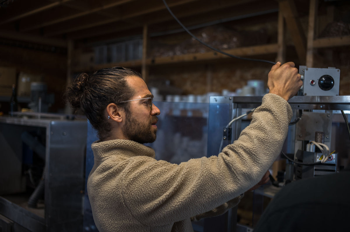 Aymeric Lemarchand réglant la ligne de production des boissons POUM! à la Ferme de Billy